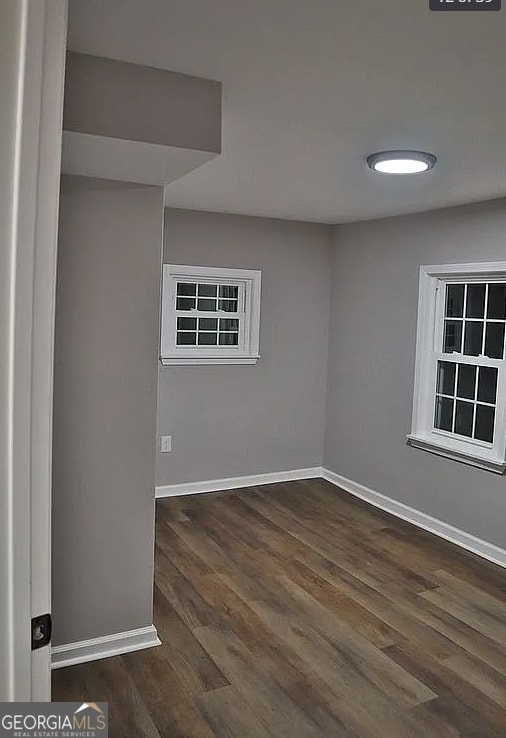 unfurnished room featuring baseboards and wood finished floors