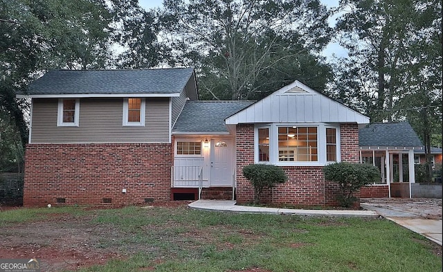 view of front facade featuring crawl space, brick siding, a front lawn, and a shingled roof