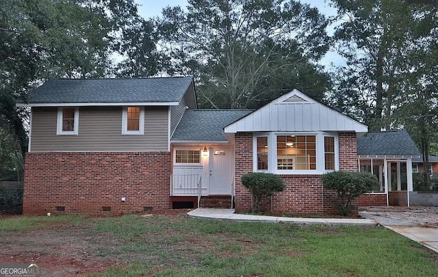 view of front facade featuring crawl space, brick siding, roof with shingles, and a front lawn