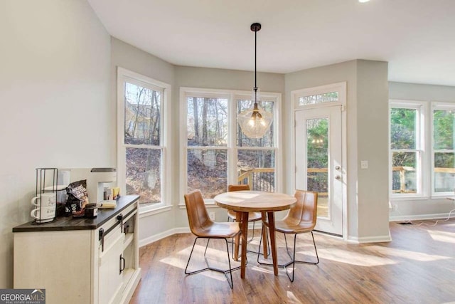 dining space with baseboards and light wood-style floors