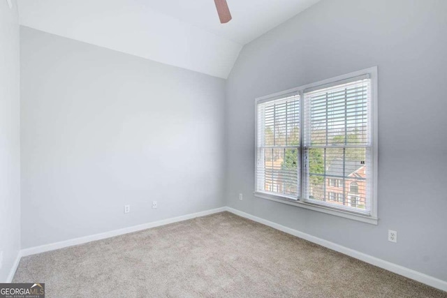 unfurnished room featuring lofted ceiling, baseboards, carpet floors, and ceiling fan