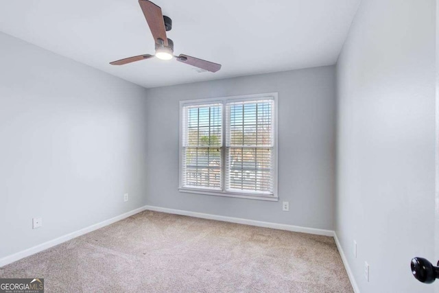 carpeted empty room featuring baseboards and ceiling fan