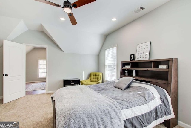 bedroom with visible vents, light carpet, ceiling fan, and vaulted ceiling