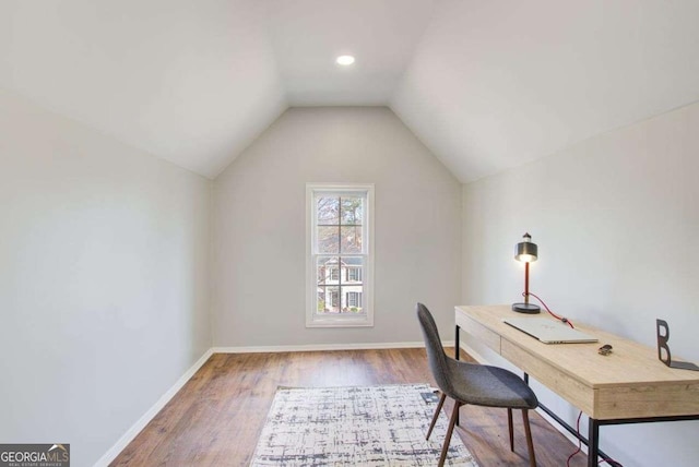 office space with vaulted ceiling, baseboards, and wood finished floors