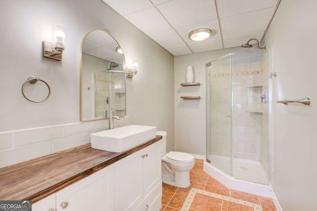 full bath featuring vanity, tile patterned floors, toilet, and a stall shower