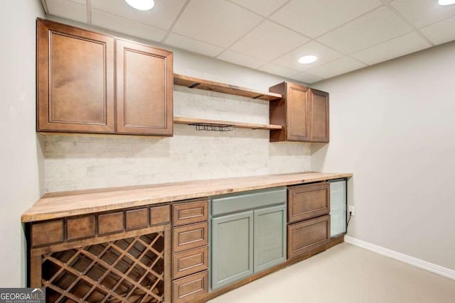 kitchen featuring backsplash, baseboards, a drop ceiling, recessed lighting, and open shelves