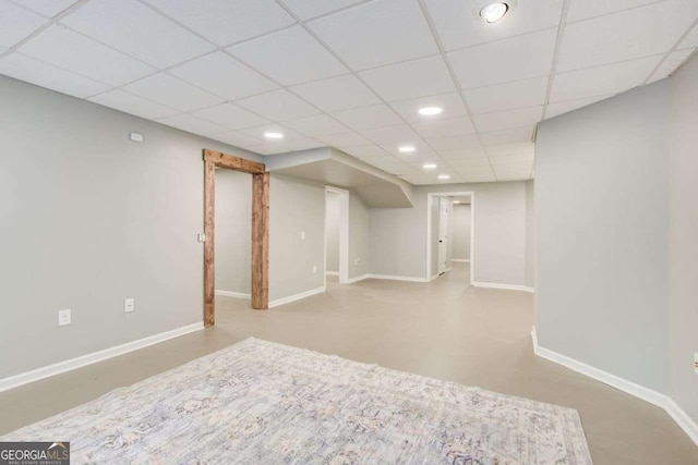 finished below grade area featuring recessed lighting, a drop ceiling, and baseboards