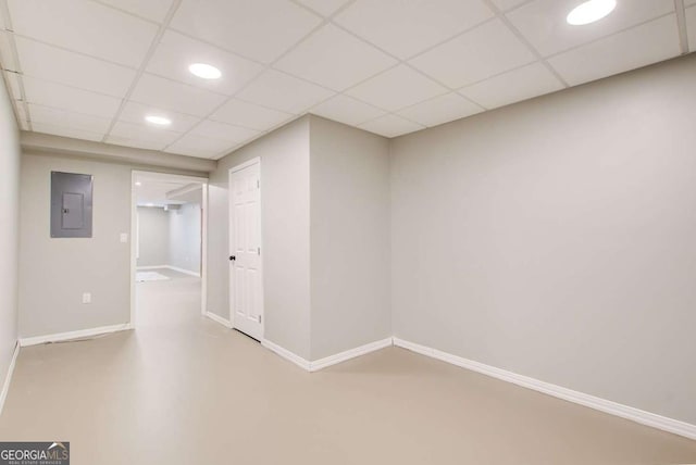 finished basement featuring electric panel, a drop ceiling, baseboards, and recessed lighting