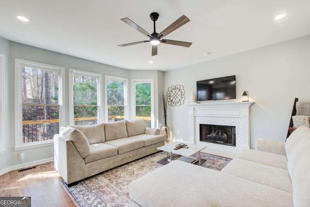 living area featuring visible vents, recessed lighting, a fireplace, and wood finished floors