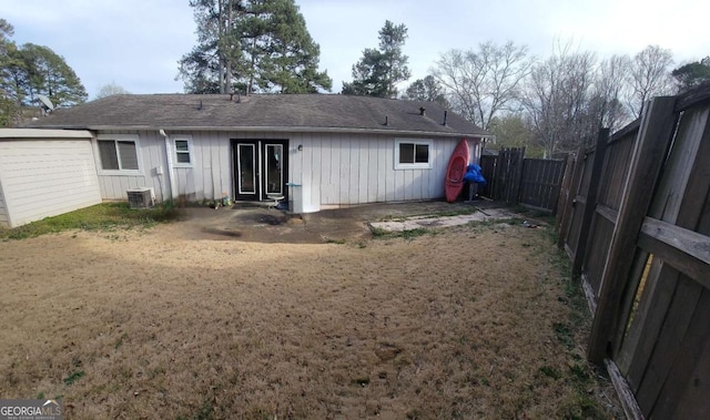 4906 Kellys Mill Dr NW, Lilburn, GA 30047 - rear view of house with board and batten siding, a fenced backyard, and a shingled roof
