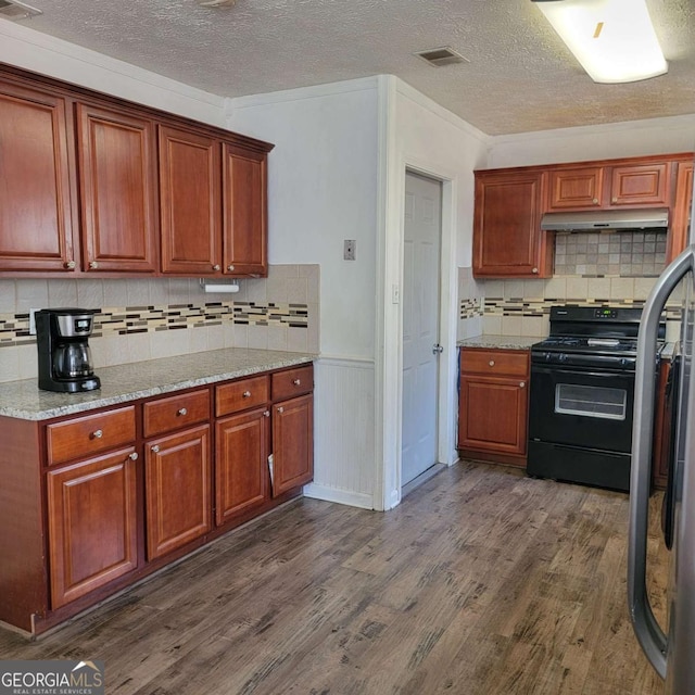 4906 Kellys Mill Dr NW, Lilburn, GA 30047 - kitchen with black gas stove, a textured ceiling, dark wood-style flooring, tasteful backsplash, and a wainscoted wall