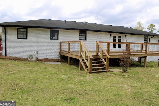 back of house with brick siding, a lawn, a deck, and ac unit