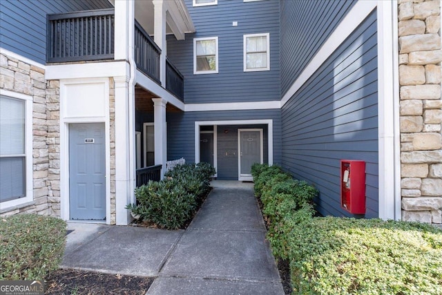 entrance to property with a balcony and stone siding