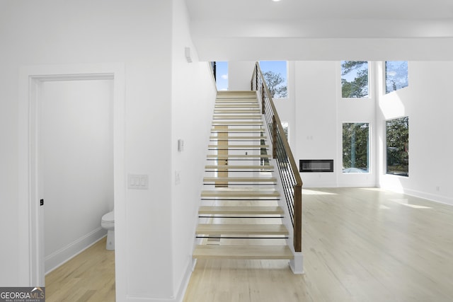 stairway with wood finished floors and baseboards