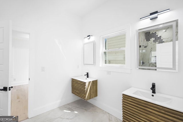 bathroom with baseboards, two vanities, a sink, walk in shower, and marble finish floor