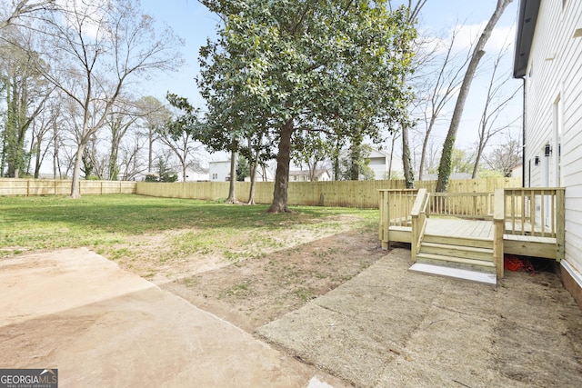 view of yard with a deck, a patio, and a fenced backyard