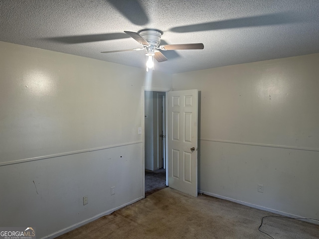 empty room with baseboards, carpet flooring, a textured ceiling, and ceiling fan