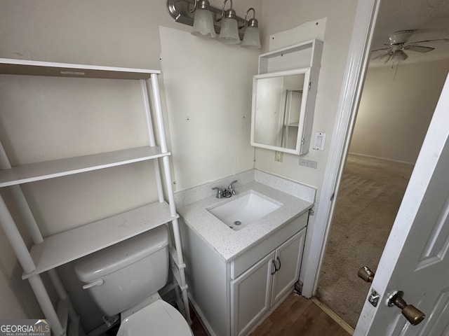 bathroom featuring vanity, toilet, and a ceiling fan