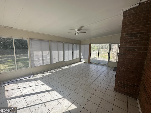 unfurnished sunroom featuring a ceiling fan and vaulted ceiling