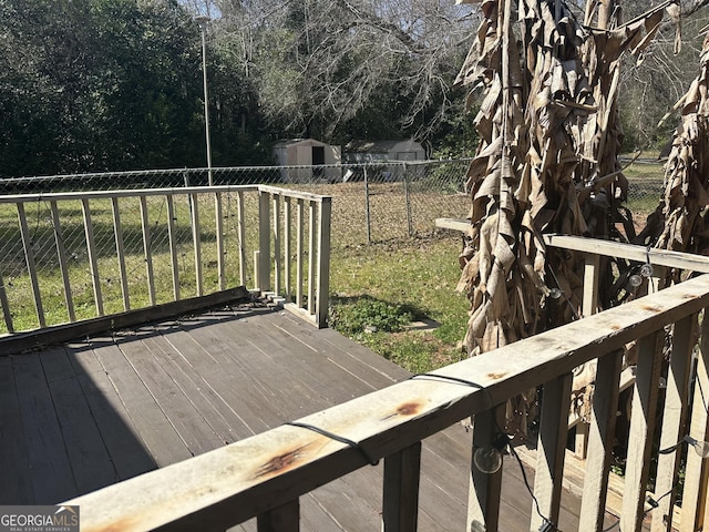 wooden deck with an outbuilding and fence