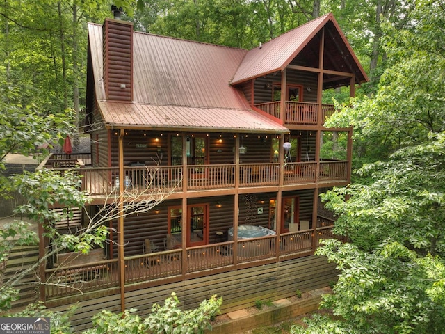 back of property featuring metal roof and a chimney