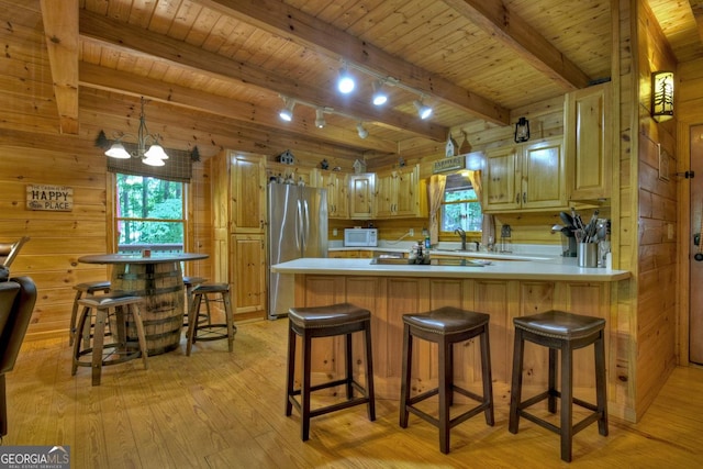 kitchen featuring wooden ceiling, light wood-style flooring, wood walls, and freestanding refrigerator