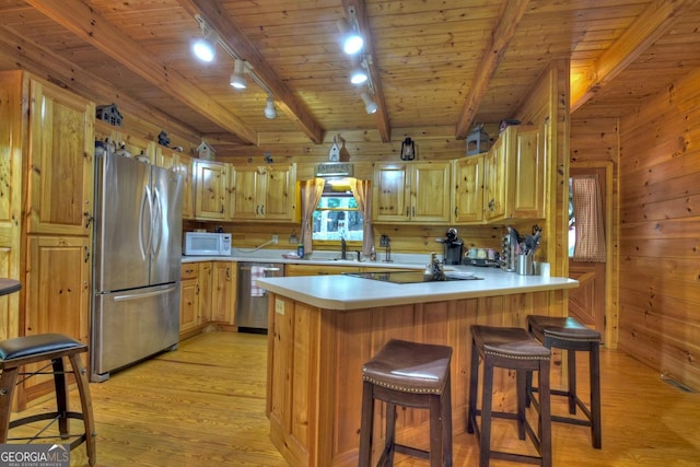 kitchen featuring wood walls, appliances with stainless steel finishes, wooden ceiling, and light wood-style floors