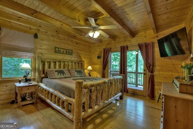 bedroom featuring beam ceiling, wooden walls, and wood ceiling