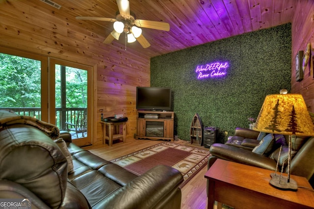 living area with a ceiling fan, wooden ceiling, and wood finished floors