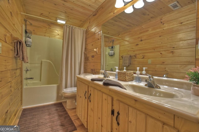 full bath featuring wooden ceiling, visible vents, wood walls, and a sink