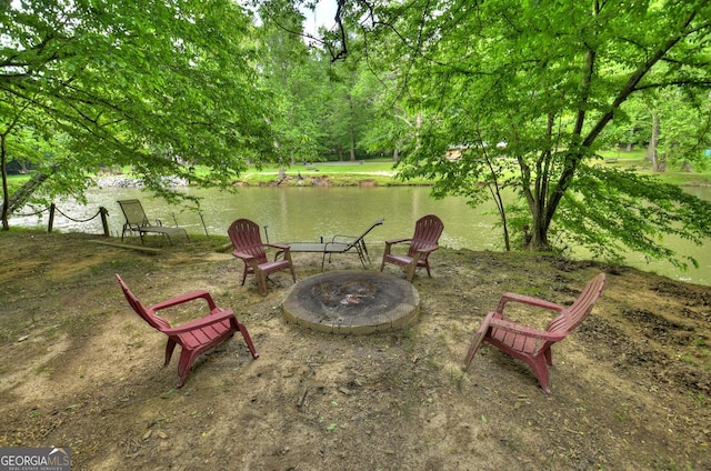 view of yard with an outdoor fire pit and a water view