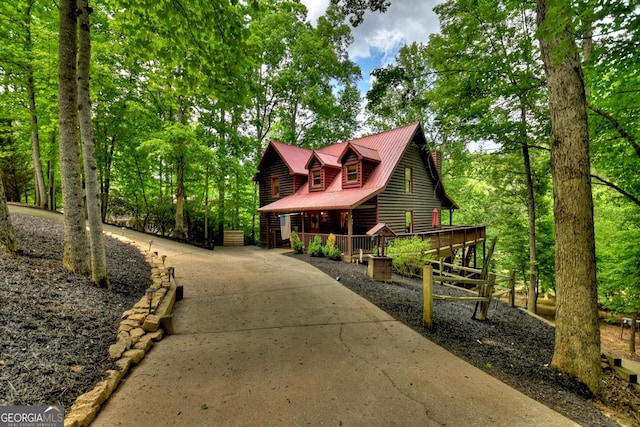 rustic home featuring a wooden deck and metal roof