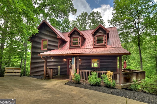 log cabin featuring faux log siding and metal roof