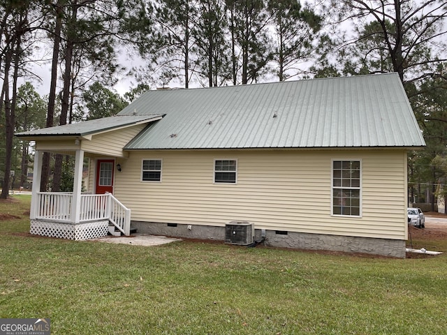 back of house with crawl space, a yard, and central AC