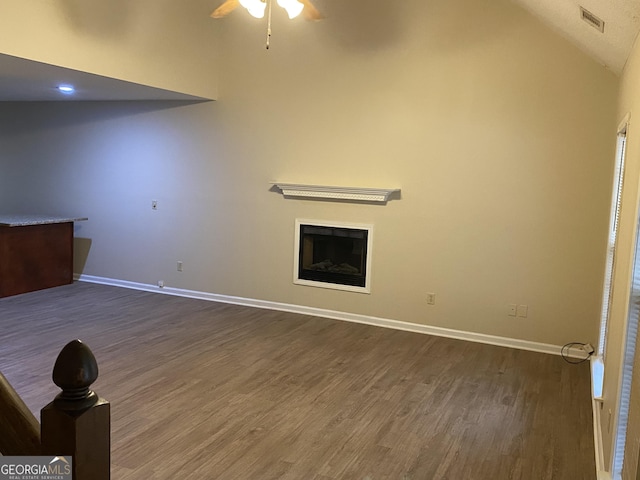 unfurnished living room with visible vents, baseboards, dark wood-type flooring, and a fireplace