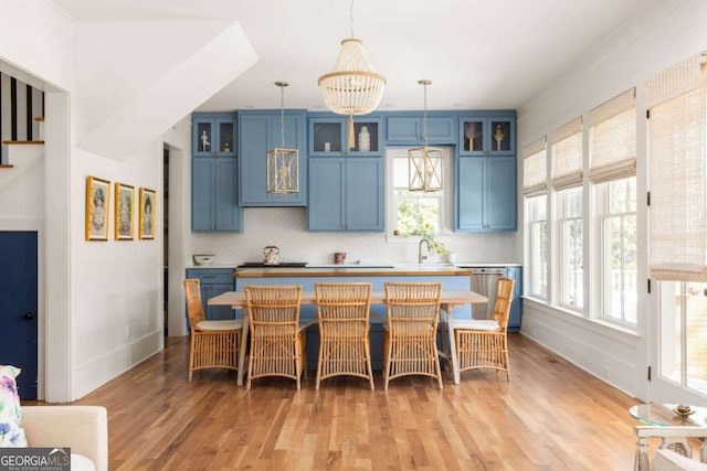 kitchen with backsplash, plenty of natural light, and blue cabinetry