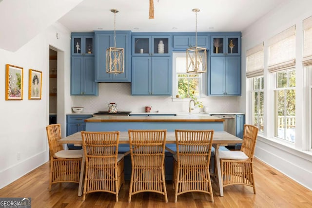 kitchen with dishwasher, blue cabinetry, tasteful backsplash, and a center island