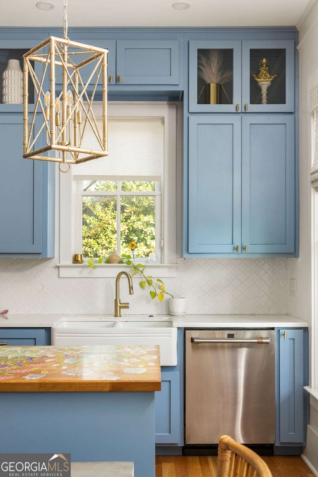 kitchen with dishwasher, blue cabinets, and a sink