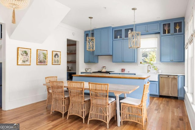 kitchen with blue cabinetry, dishwasher, a center island, and a sink