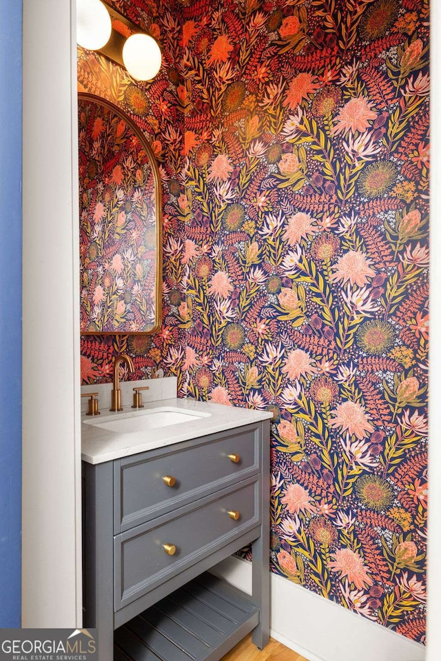 details featuring wallpapered walls, vanity, and indoor wet bar