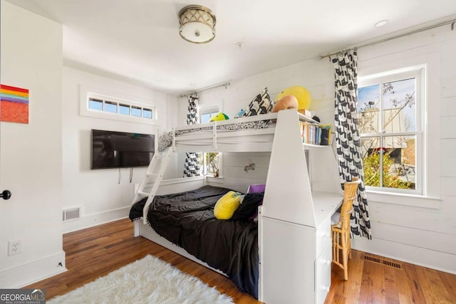 bedroom featuring visible vents, multiple windows, and wood finished floors