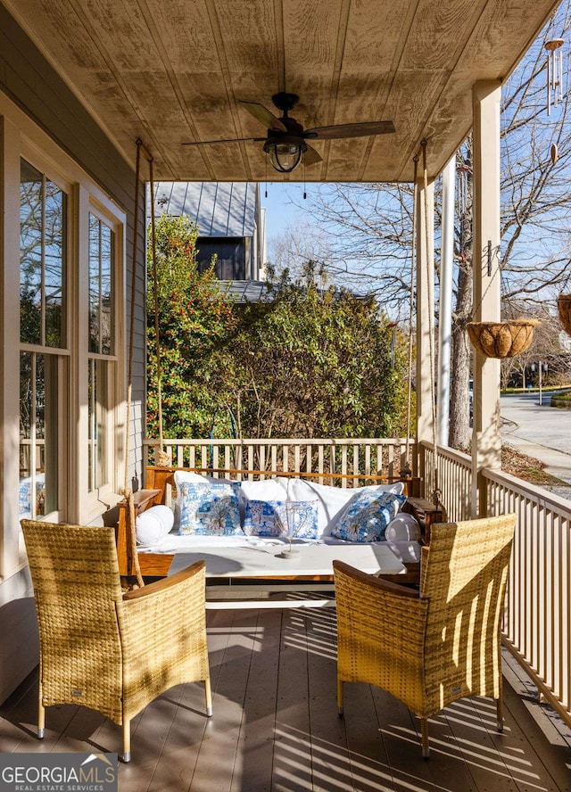 wooden terrace featuring an outdoor living space and a ceiling fan