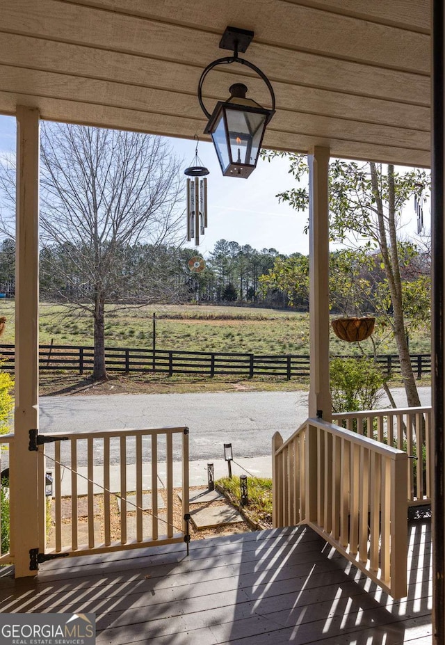 deck featuring a rural view and fence