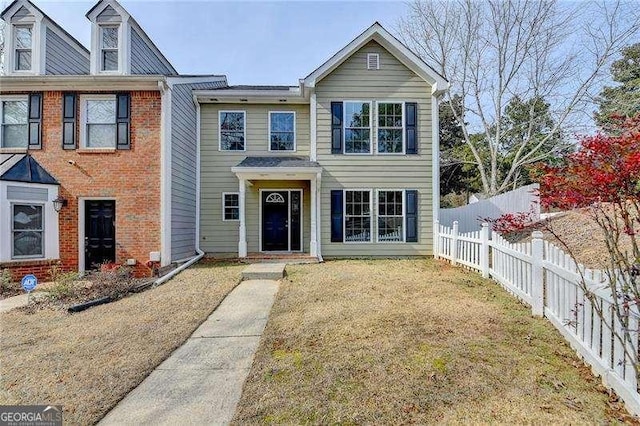 view of property with a front lawn and fence