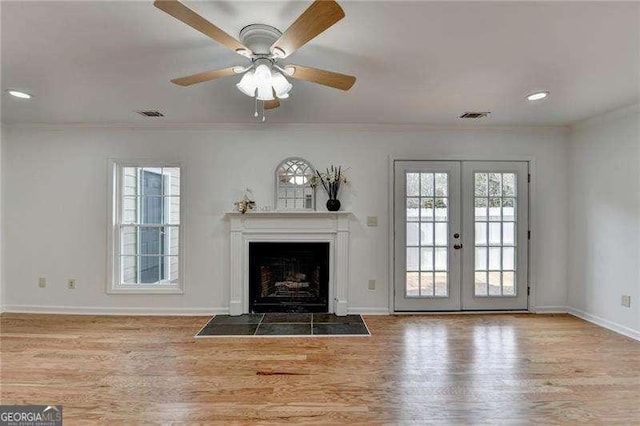 unfurnished living room featuring visible vents, ornamental molding, wood finished floors, french doors, and baseboards