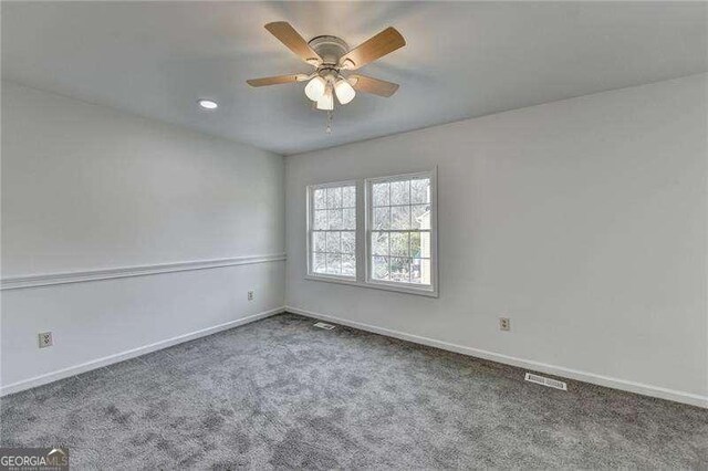 unfurnished room featuring baseboards, visible vents, carpet floors, and ceiling fan