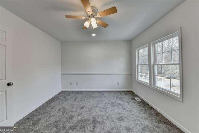 empty room featuring visible vents, baseboards, and carpet