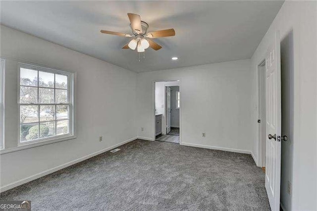 unfurnished bedroom with ensuite bath, a ceiling fan, baseboards, and carpet floors