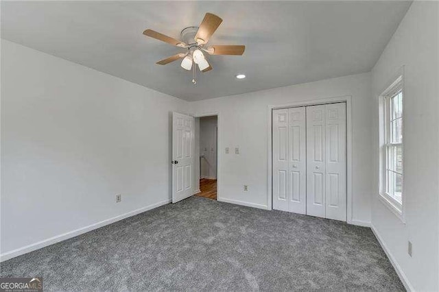 unfurnished bedroom featuring carpet flooring, a ceiling fan, baseboards, and a closet