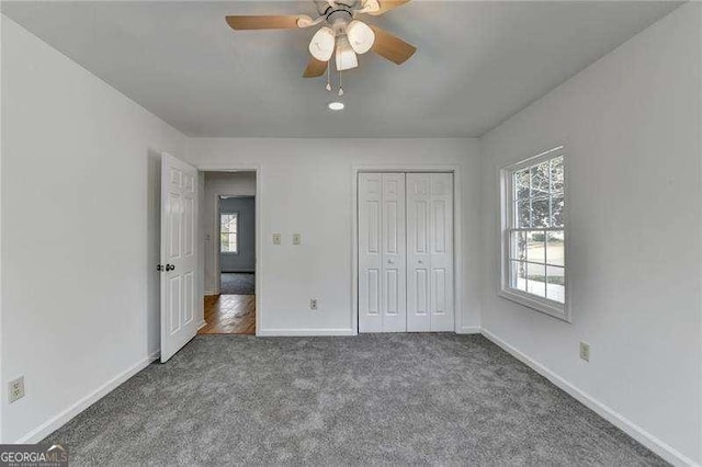 unfurnished bedroom featuring a closet, ceiling fan, baseboards, and carpet